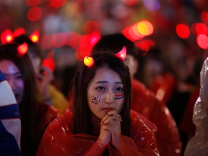 A South Korean fan watches a live TV broadcast of her team's 2014 World Cup match against Algeria, in Seoul